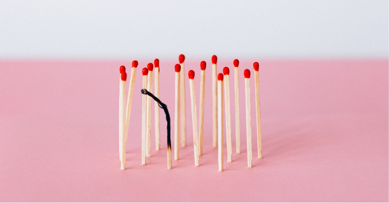 Groupe d’allumettes dressées, dont une est noire et consumée au centre — métaphore du burn-out illustrant le désengagement managérial et son impact sur l’engagement des collaborateurs.