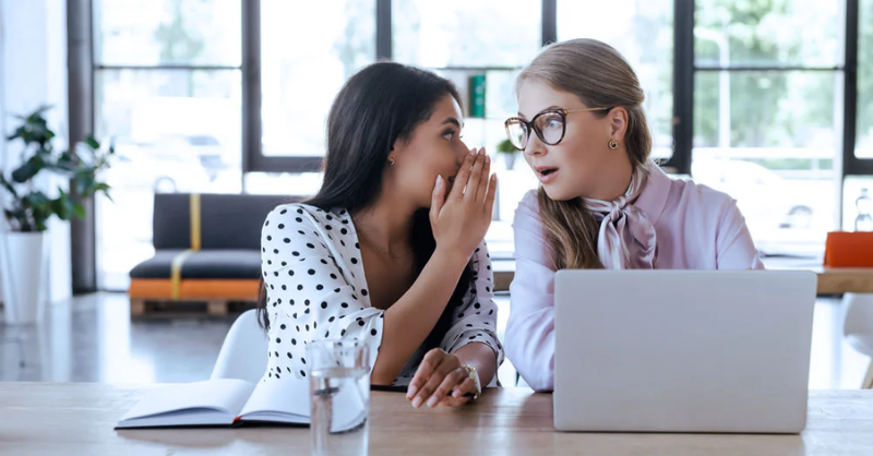deux femmes discutant sur leur poste de travail