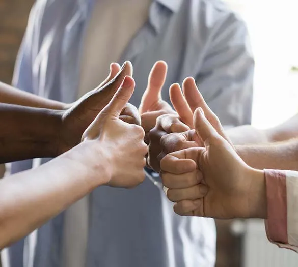 Un groupe de collaborateurs faisant des pouces en l'air