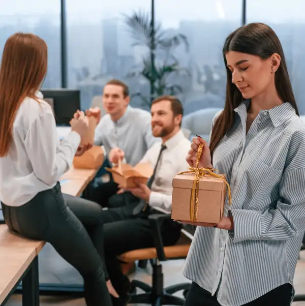 Groupe d'employés ouvrant des cadeaux de leur entreprise