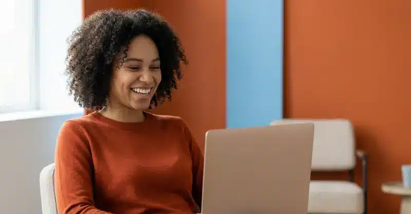 Femme souriante devant son ordinateur