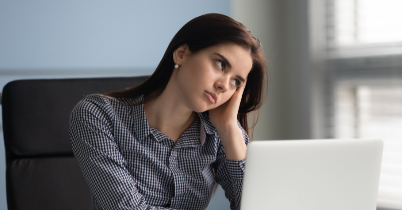Femme qui s'ennuie au travail devant son écran d'ordinateur
