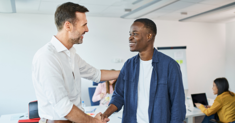 Un homme sert la main à un autre homme pour lui souhaiter la bienvenue dans l'entreprise