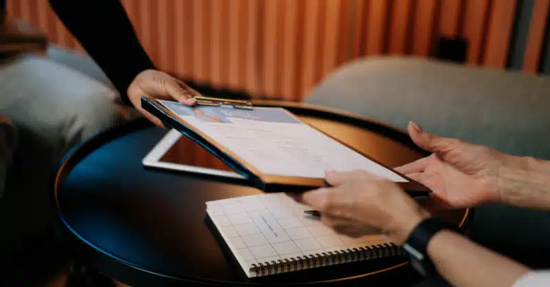 Personne en entretien qui donne son CV à son interlocutrice