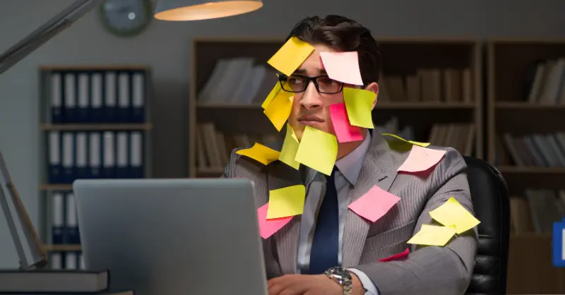 Homme débordé avec des posts-it sur le visage