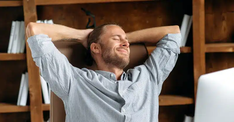 Homme détendu les mains derrière la tête